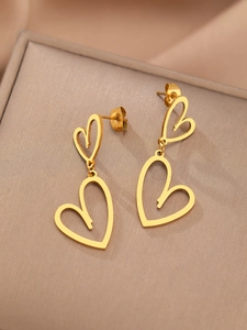 Vue macro de boucles d'oreilles doubles cœurs dorés sur soie, finition polie et détails