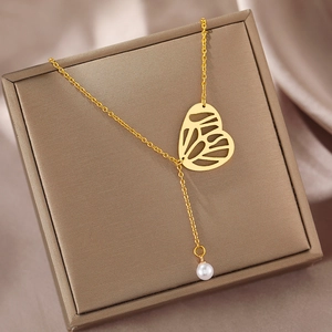 Golden Y-shaped butterfly necklace with faux pearl pendant on a silk jewelry box