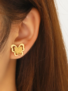 Gros plan de boucles d'oreilles papillon double couche en titane plaqué or 18 carats