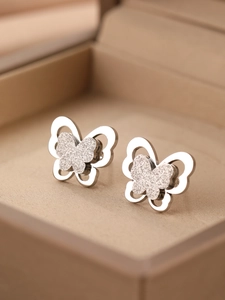 Vue macro de boucles d'oreilles papillon avec paillettes givrées et bords évidés