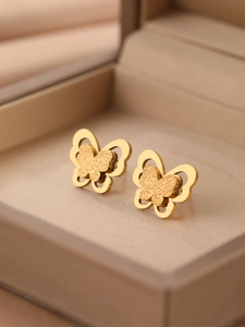 Gros plan de boucles d'oreilles papillon en or 18 carats avec texture mate et double couche