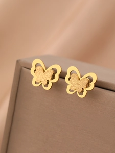 Détail de boucles d'oreilles papillon en or 18k avec couches de métal dépolies et évidées