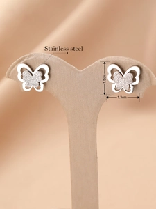 Détail de boucles d'oreilles papillon en acier inoxydable argenté sur un présentoir