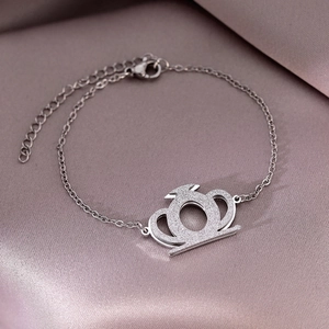 Bracelet élégant en acier inoxydable avec pendentif couronne sur fond de soie