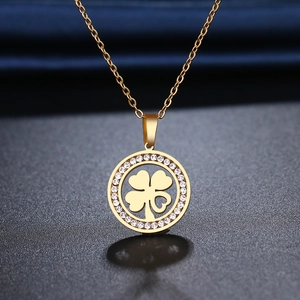 Collier trèfle doré avec cristaux blancs sur fond élégant en soie bleu marine