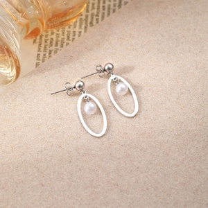 Vue détaillée de boucles d'oreilles géométriques en perles sur fond minimaliste