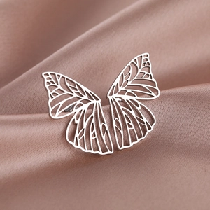 Minimalistischer Edelstahl-Schmetterlingsring auf elegantem Roségold-Seidenstoff
