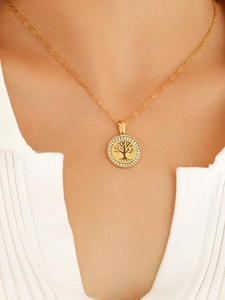 Dettaglio della collana dorata albero della vita con zirconi indossata su un modello