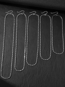 Vertical display of five titanium steel Figaro chain necklaces in various lengths