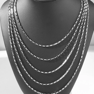 Layered silver titanium steel box chain necklaces shown on a black neck mannequin