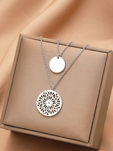 Detailed macro shot of vintage silver double-layer necklace with hollow sunburst pendants