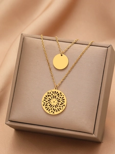 Detail of vintage gold layered necklace with bohemian hollow mandala and solid round pendants