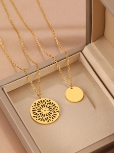 Close-up of gold double-layer necklace with mandala carving and round pendants
