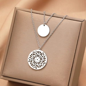 Double-layered silver necklace with a solid small disc and a hollow mandala pendant