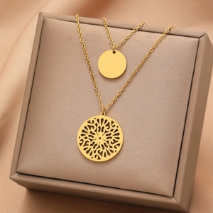 Golden double layer necklace featuring minimalist disc and hollow floral pendant
