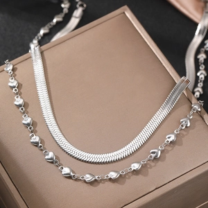 Silver layered necklace set with a flat herringbone snake chain and heart pendant accents