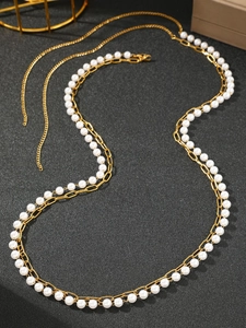 Detailed macro view of French style double-layer gold plated chain with white pearls