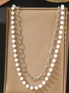 Detail of double-layer stainless steel waist chain with white pearls and paperclip link design