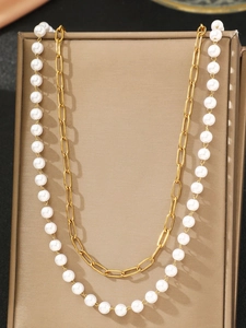 Detail of double-layer stainless steel gold waist chain with elegant white pearls