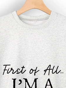 Detail of grey crewneck sweatshirt featuring First of All I'm a Delight black lettering