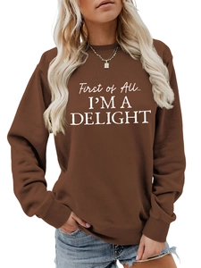 Detail showing white First of All I'M A DELIGHT text on a brown crewneck sweatshirt