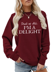 Close-up of burgundy sweatshirt showing ribbed cuffs and white 'I'M A DELIGHT' lettering