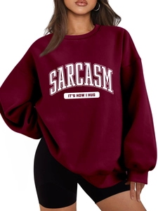 Detail of burgundy oversized sweatshirt with white SARCASM IT'S HOW I HUG slogan print