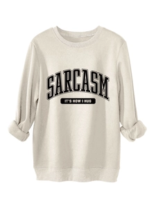 Detailed view of cream sweatshirt fabric with black Sarcasm It's How I Hug slogan print