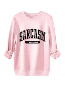 Close-up of pink crewneck sweatshirt featuring Sarcasm slogan and ribbed cuffs detail