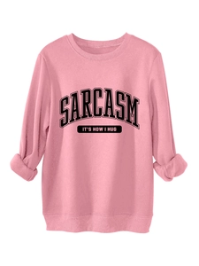 Close-up of pink crewneck sweatshirt featuring black Sarcasm letter print and ribbed cuffs