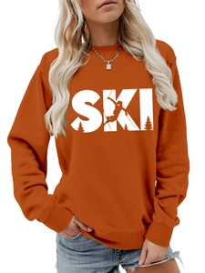 Detailed close-up of burnt orange crewneck sweatshirt with white SKI graphic and ribbed cuffs