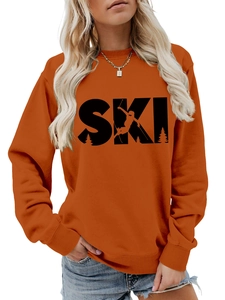 Close-up of bright orange crewneck sweatshirt with black SKI graphic and ribbed details