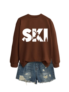 Detail of brown SKI sweatshirt featuring ribbed cuffs and blue distressed denim shorts