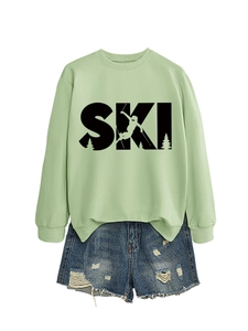 Detail of light green sweatshirt with SKI graphic and blue distressed denim shorts