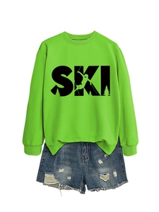 Close-up of SKI print on green sweatshirt and distressed blue denim shorts details