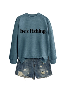 Flat lay of a blue long-sleeve crewneck sweatshirt with he's fishing text and denim shorts