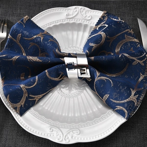 Elegant silver metal napkin ring on white ceramic plate for formal table decor