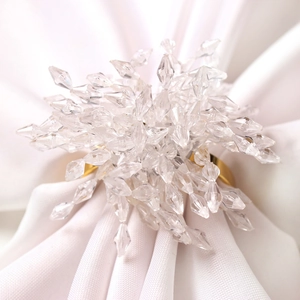 Elegant gold napkin ring with crystal beaded floral design on white fabric