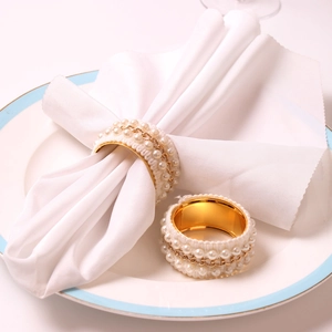 Elegant gold pearl napkin ring with intricate lace chain detail for wedding table decor