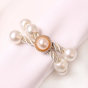 Elegant beaded napkin ring with large white pearls and a champagne centerpiece