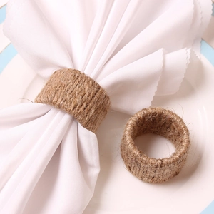 Rustic handmade jute napkin rings on a white plate with blue border for table decor