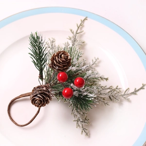 Christmas napkin ring featuring pine cones, red berries and snow-covered pine needles