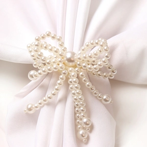 Elegant pearl bow napkin ring with double-layered weave and dangling beads on silk