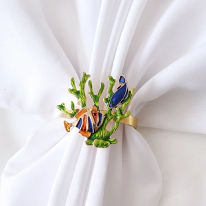 Coastal coral reef napkin ring with colorful fish and enamel finish on white napkin