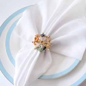 Golden nautical ship wheel napkin ring with colorful enamel seahorse and seashell charms