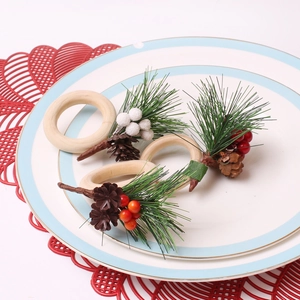 Detail eines Weihnachts-Serviettenrings mit roten Beeren, Tannennadeln und Zapfen