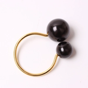 Servilletero minimalista en forma de U dorado con dos esferas negras brillantes pulidas