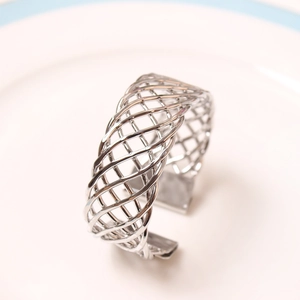 Macro detail of silver woven mesh napkin ring with intricate crisscross wire design