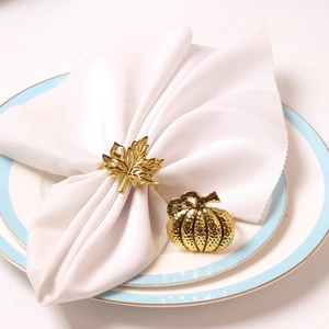 Detalle de servilleteros de hoja de membrillo y calabaza en metal dorado para el otoño