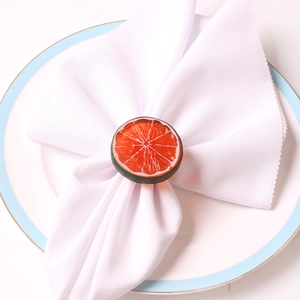 Realistic orange slice napkin ring on a white cloth for a fresh table setting